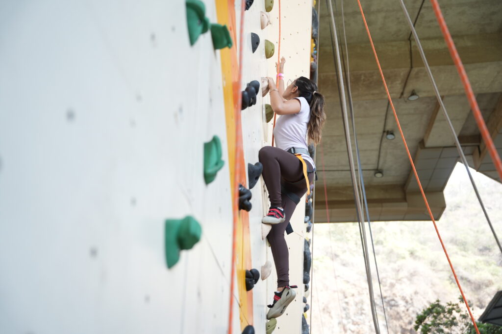 A woman climbing a route at High Rock Climbing Arena, Powai