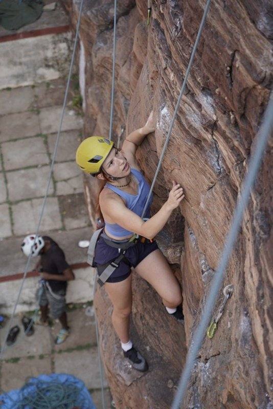 A woman climbing the sandstone wall at the Badami retreat